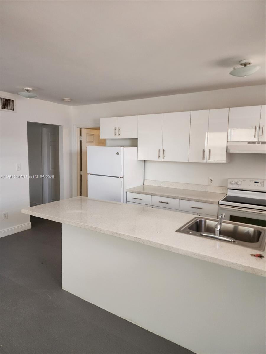 14240 Northwest 22nd Avenue, Unit 3 Opa-Locka, FL 33054 - Photo 31 of 49 a kitchen with refrigerator and cabinets