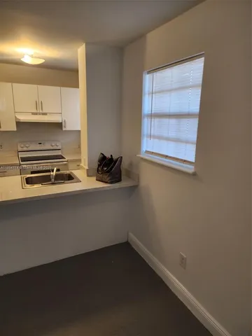 a room with a sink a stove and a window