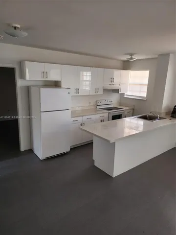 a view of an empty room with wooden floor and closet