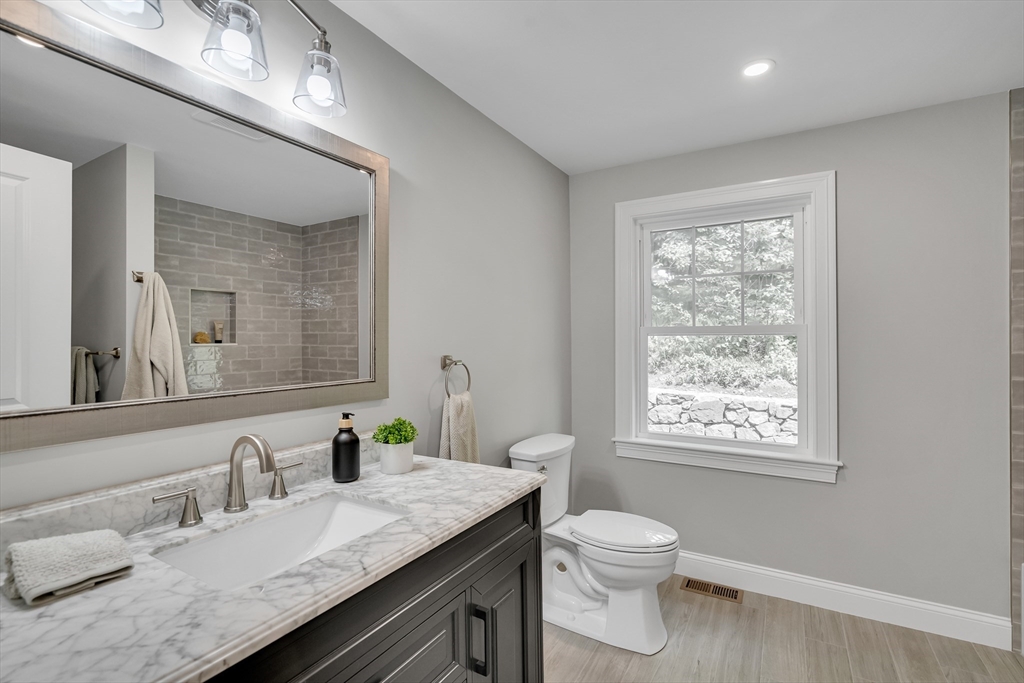 956 Waltham Street Lexington, MA 02421 - Photo 13 of 41 a bathroom with a granite countertop sink a toilet and a mirror