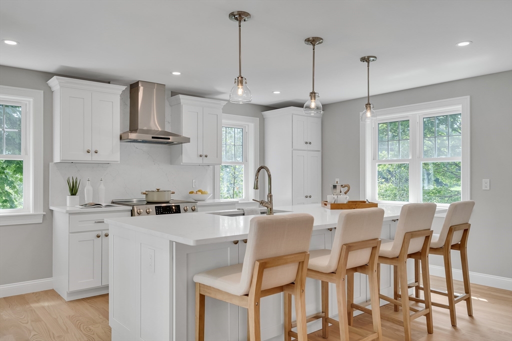 956 Waltham Street Lexington, MA 02421 - Photo 9 of 41 a kitchen with stainless steel appliances granite countertop a stove a sink a kitchen island with a dining table and chairs