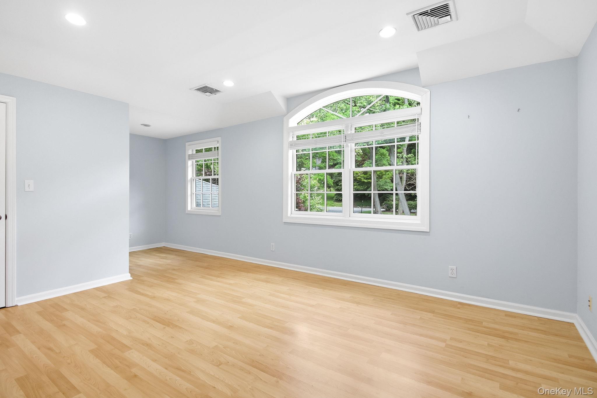 26 Century Ridge Road Purchase, NY 10577 - Photo 23 of 50 Upstairs Bedroom #3: Spacious room with wood-finish flooring, light blue walls, and a large arched window