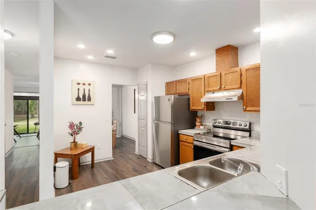 a kitchen with stainless steel appliances granite countertop a sink a stove and cabinets