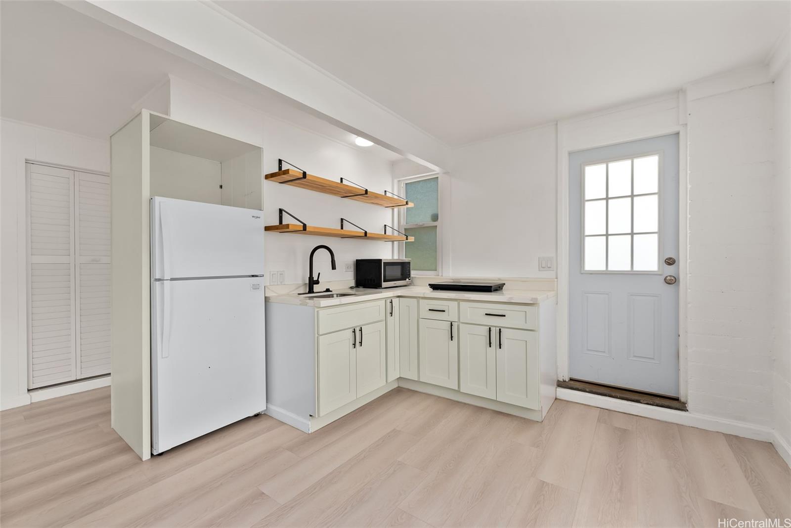 2811 Henry Street Honolulu, HI 96817 - Photo 18 of 25 Convenient and stylish, this kitchenette area features a sink, space for a fridge, and a charming blue door leading straight outside.