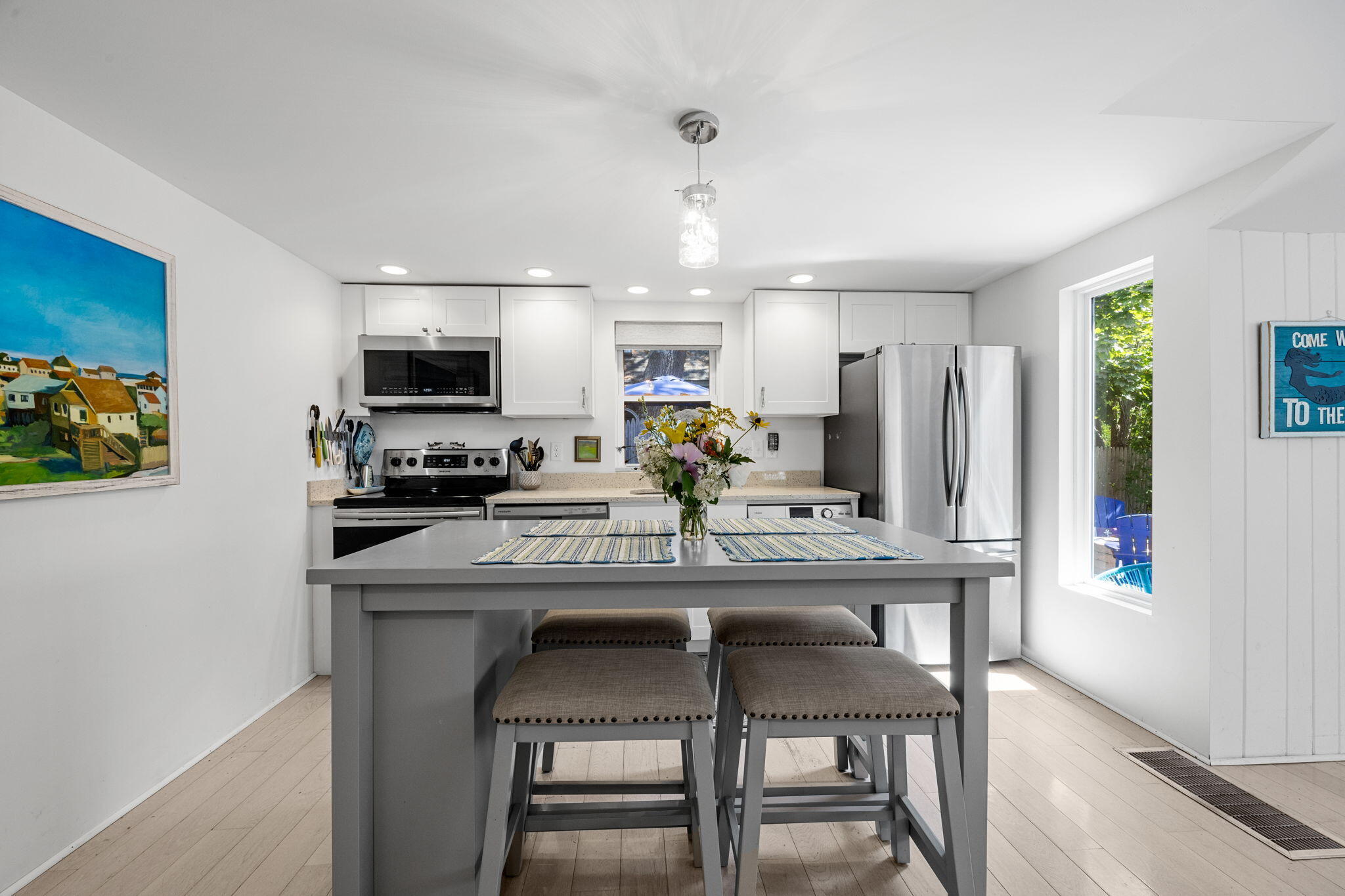 210 Chequessett Neck Road, Unit C Wellfleet, MA 02667 - Photo 11 of 37 a kitchen with kitchen island granite countertop a table chairs microwave and cabinets