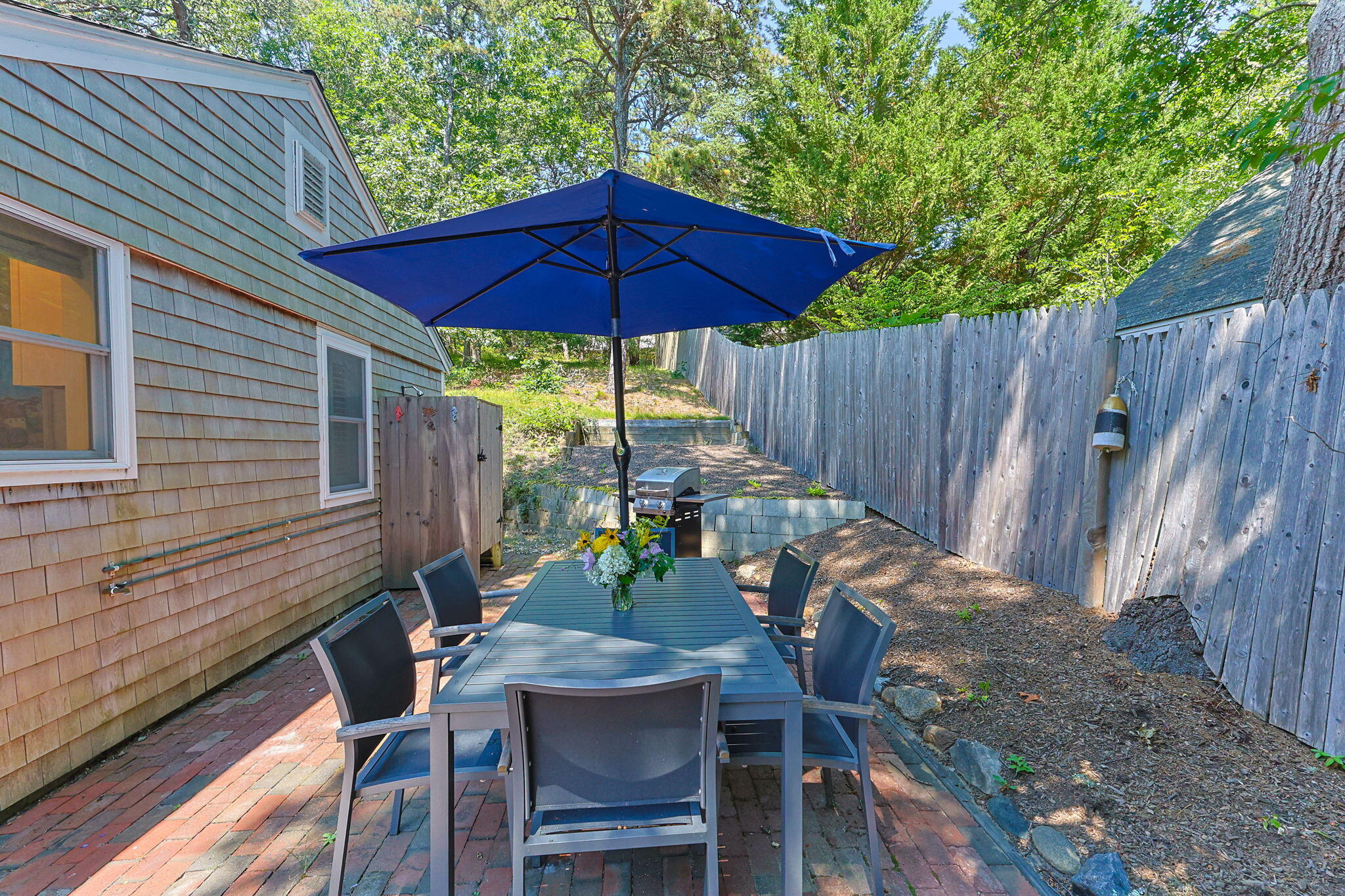 210 Chequessett Neck Road, Unit C Wellfleet, MA 02667 - Photo 29 of 37 a view of a table and chairs under an umbrella