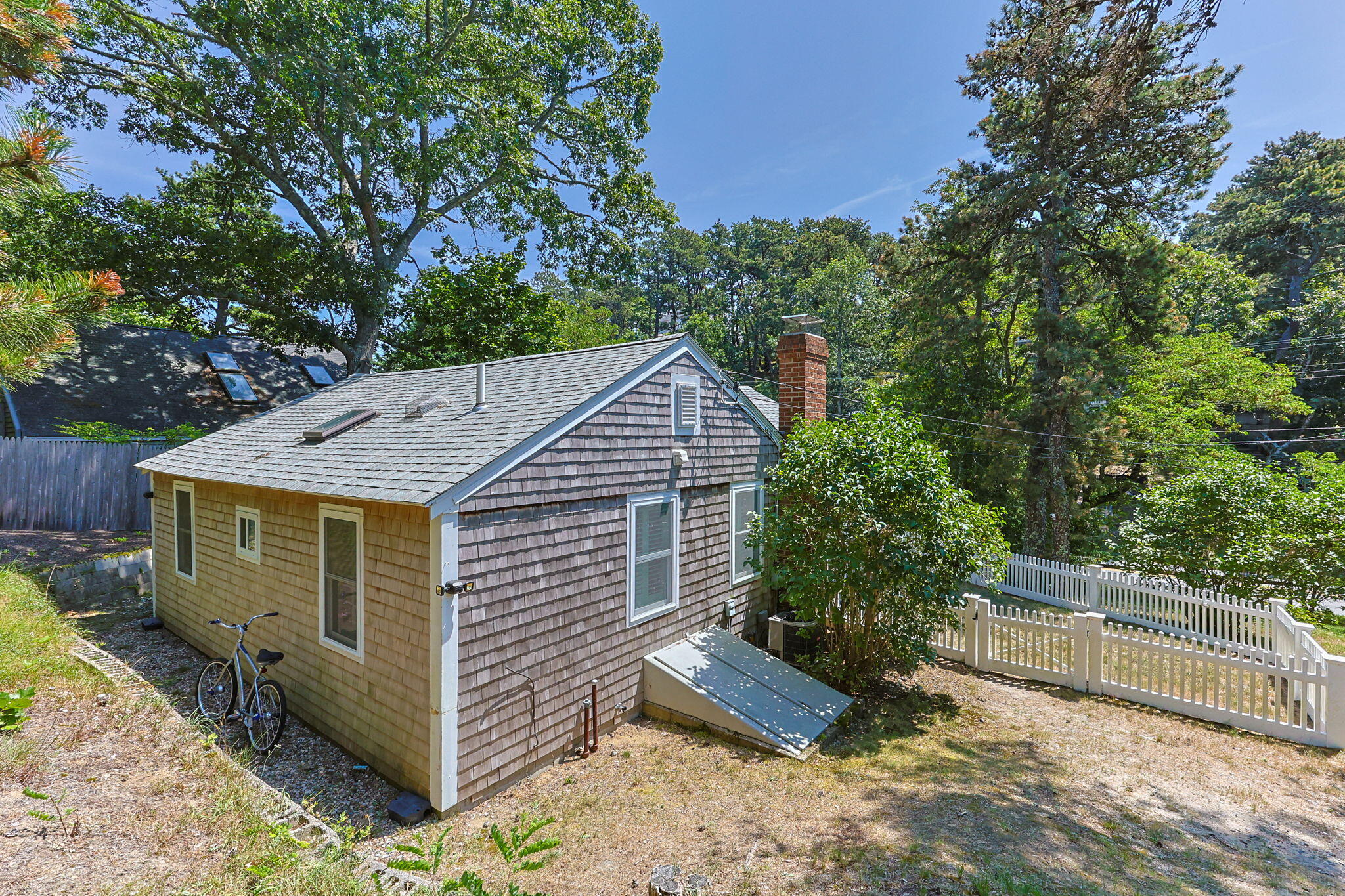 210 Chequessett Neck Road, Unit C Wellfleet, MA 02667 - Photo 35 of 37 a view of a house with a yard and large tree and wooden fence