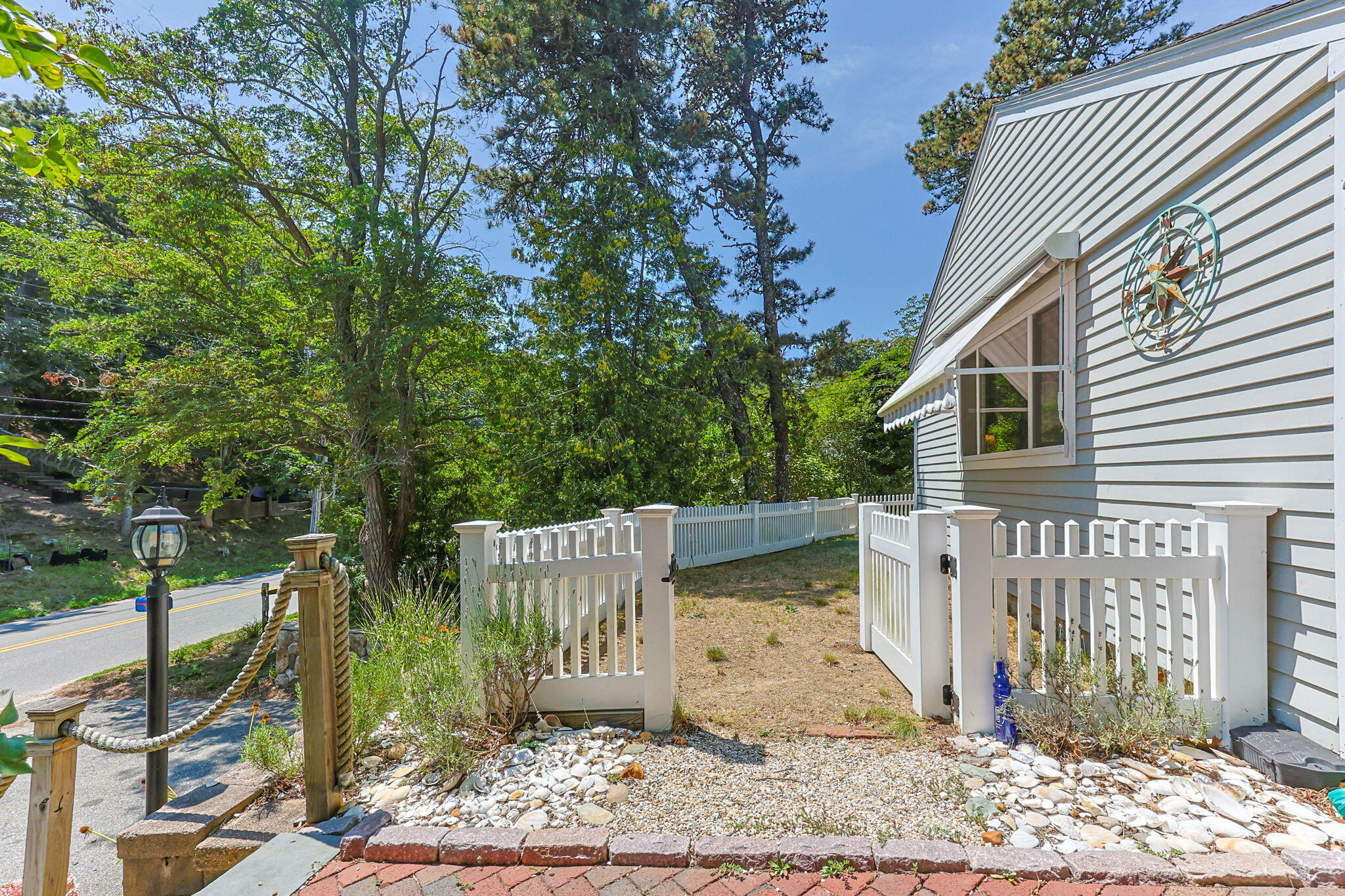 210 Chequessett Neck Road, Unit C Wellfleet, MA 02667 - Photo 4 of 37 a view of a wooden house with a large tree and wooden fence