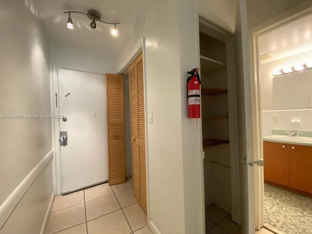 a view of a hallway with closet and bathroom