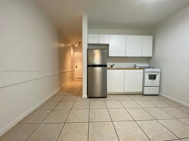 a kitchen with a stove a refrigerator and cabinets