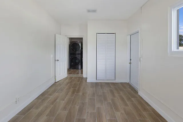 a view of an empty room with closet and a window