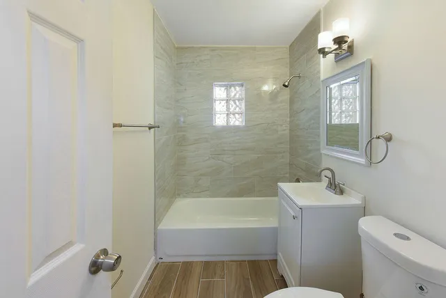 a bathroom with a sink toilet vanity and bathtub