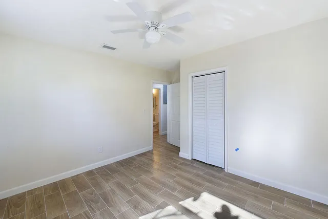an empty room with a ceiling fan and carpet