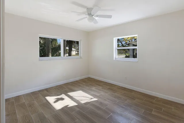 a view of a big room with wooden floor and windows