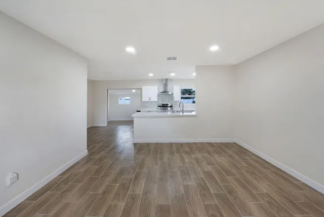 a view of a kitchen with a sink and wooden floor
