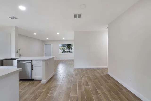 a view of a kitchen with wooden floor and a sink