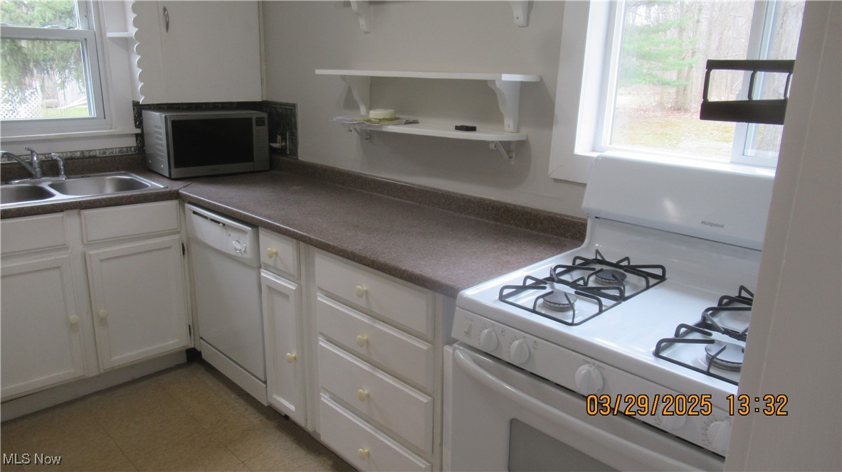 36505 Pettibone Road Solon, OH 44139 - Photo 20 of 24 Kitchen with a sink, open shelves, white cabinetry, white appliances, and dark countertops
