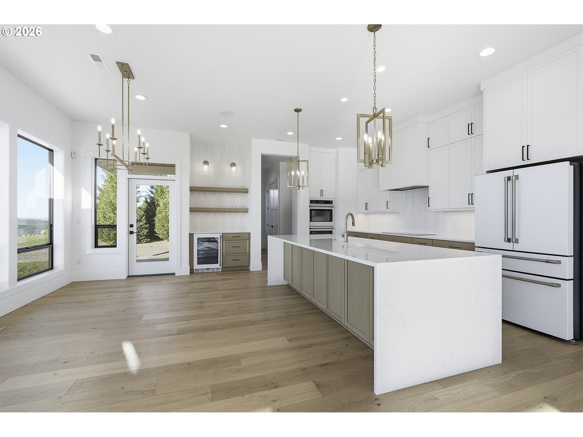 35921 Southwest Bald Peak Road Hillsboro, OR 97123 - Photo 12 of 48 a large kitchen with kitchen island a stove a refrigerator a sink and a fireplace with wooden floor