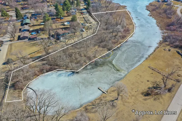 a view of water heater and room with wooden floor