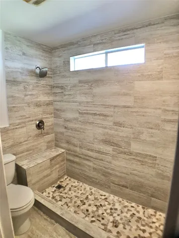 a bathroom with a toilet and a shower