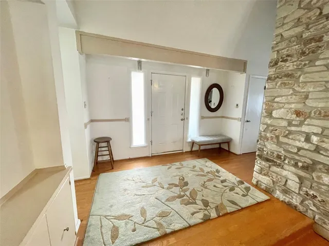 a view of a livingroom with wooden floor and bathroom space
