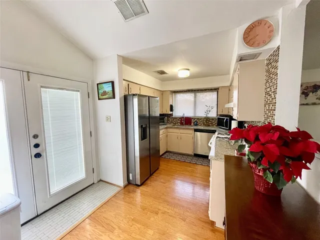 a kitchen that has a lot of cabinets and refrigerator