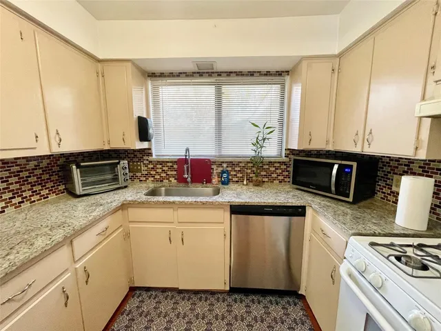 a kitchen with stainless steel appliances a stove a sink and a microwave