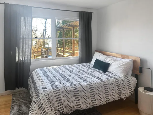 a large bed sitting in a bedroom next to a window