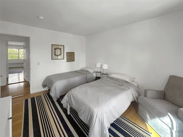 a bedroom with two beds and painting on the wall