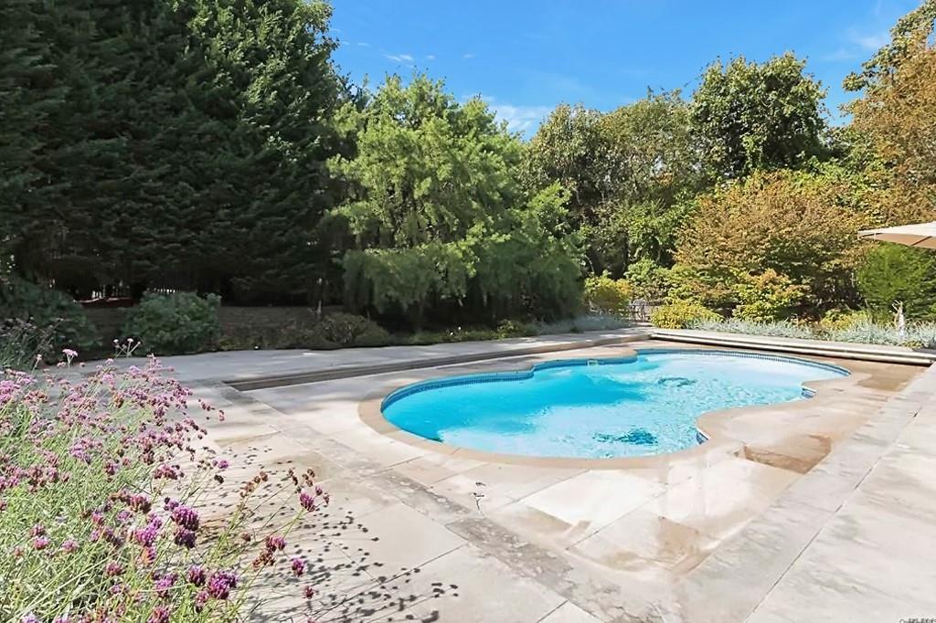 250 Pine Tree Court Cutchogue, NY 11935 - Photo 22 of 25 a view of a swimming pool with a yard