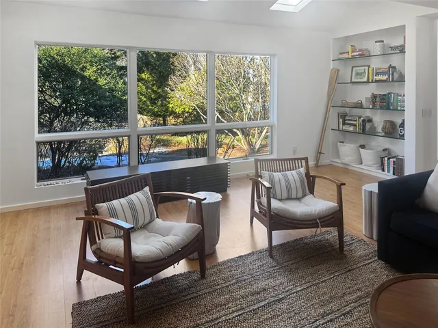a living room with furniture and a floor to ceiling window