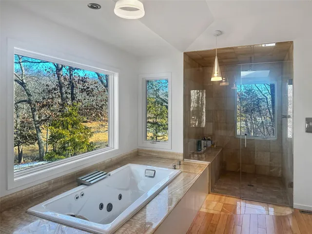 a bathroom with a tub a sink and a large window