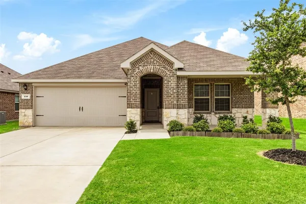 a front view of a house with a garden and yard