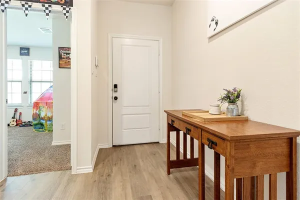 a living room with stainless steel appliances kitchen island granite countertop a sink dishwasher a dining table and chairs with wooden floor