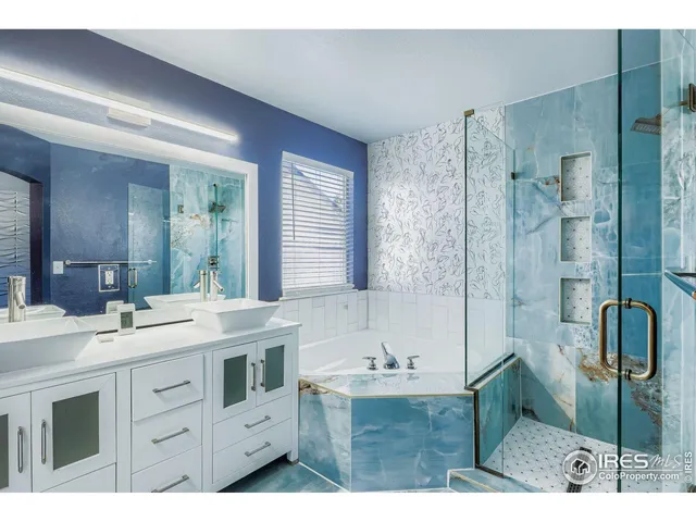 a bathroom with a sink double vanity granite tub shower and a mirror