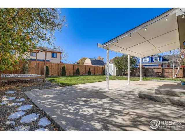a view of a house with backyard and tree