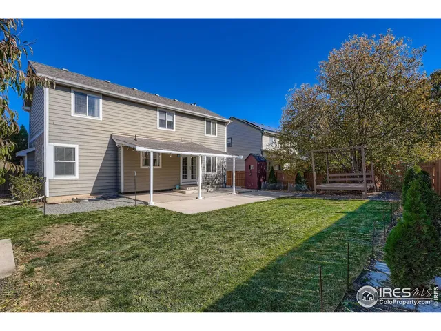 a view of a house with backyard and sitting area