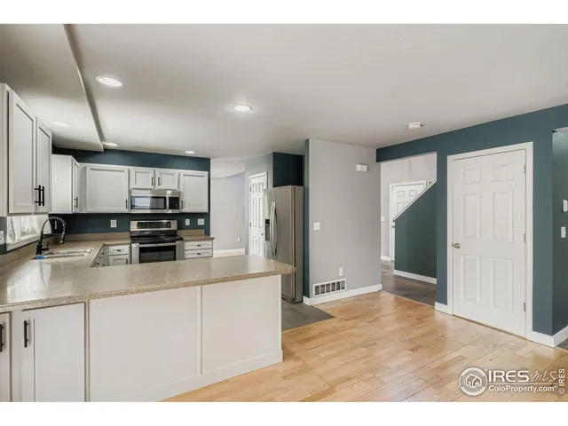 a kitchen with stainless steel appliances granite countertop a refrigerator a stove and a sink