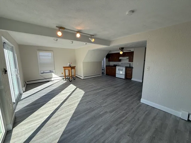 a view of a hallway with wooden floor and furniture