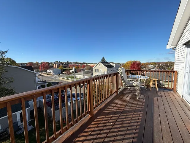 a balcony with wooden floor and city view