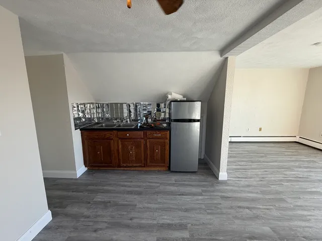 a kitchen with stainless steel appliances a refrigerator and a wooden floor