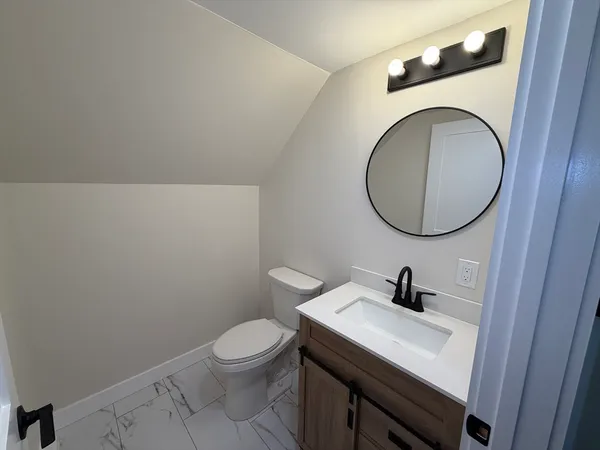 a bathroom with a toilet a sink and a mirror