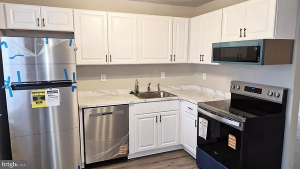 a kitchen with stainless steel appliances a stove microwave and sink