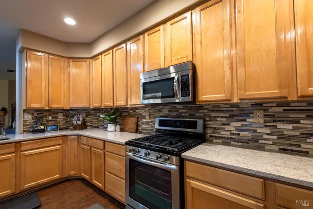 a kitchen with stainless steel appliances a stove sink and microwave