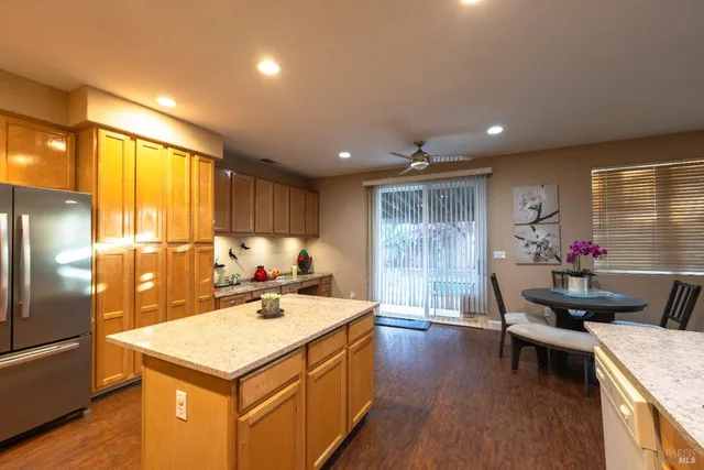 a kitchen with a sink refrigerator and wooden floor