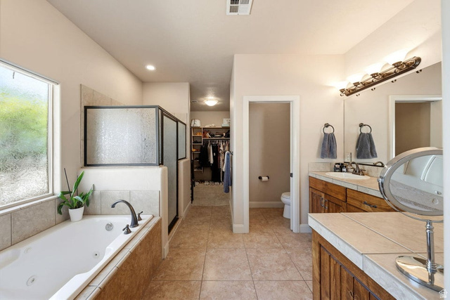 1609 East 10 S Street St. George, UT 84790 - Photo 30 of 68 Bathroom featuring a jetted soaking tub, a separate shower with frosted glass enclosure, dual vanity sinks, and tile flooring