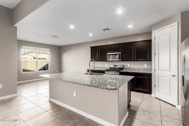 a kitchen with stainless steel appliances granite countertop a sink and a stove