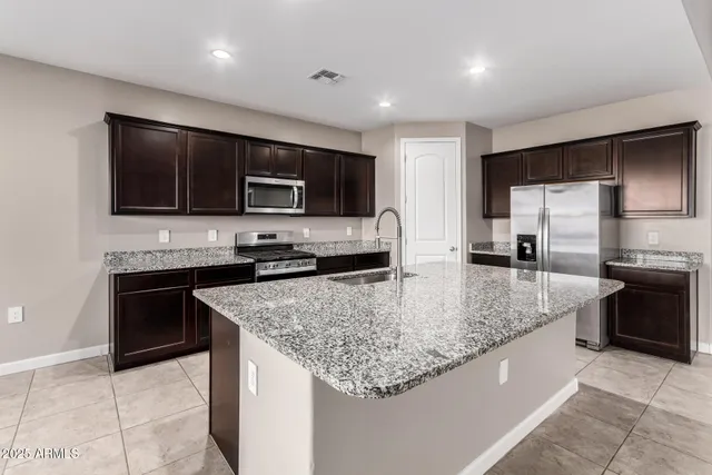 a kitchen with stainless steel appliances granite countertop a sink refrigerator and microwave