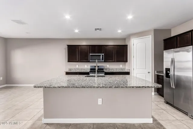a view of a kitchen with a sink a counter top space cabinets and stainless steel appliances