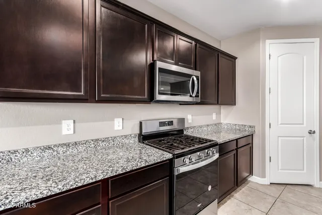 a kitchen with granite countertop stainless steel appliances and cabinets